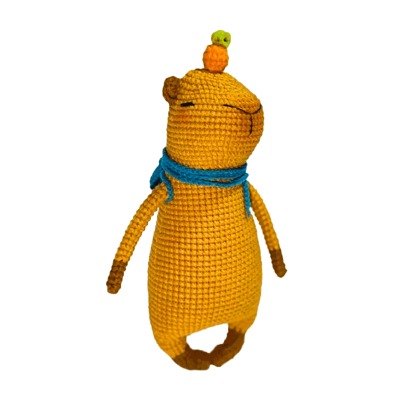Handmade yellow capybara amigurumi pattern with blue scarf and small orange and green crocheted fruits on head