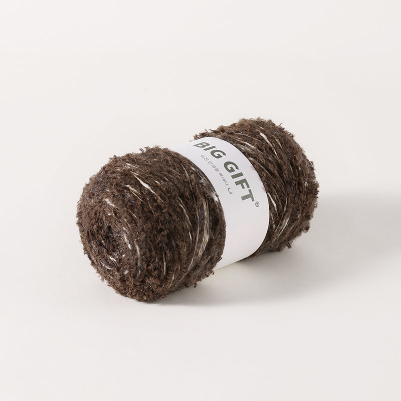 Brown skein of artisan wool blend for crochet with textured fibers and white label