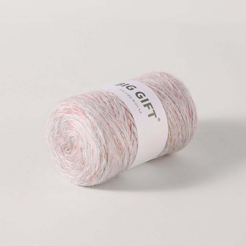 Soft skein of artisan wool blend for crochet in pastel pink and white tones with label