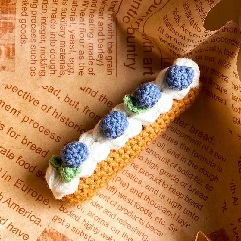 The Knit Krazy crochet eclair pattern beginner kit featuring a handmade crochet eclair with blue and white flowers