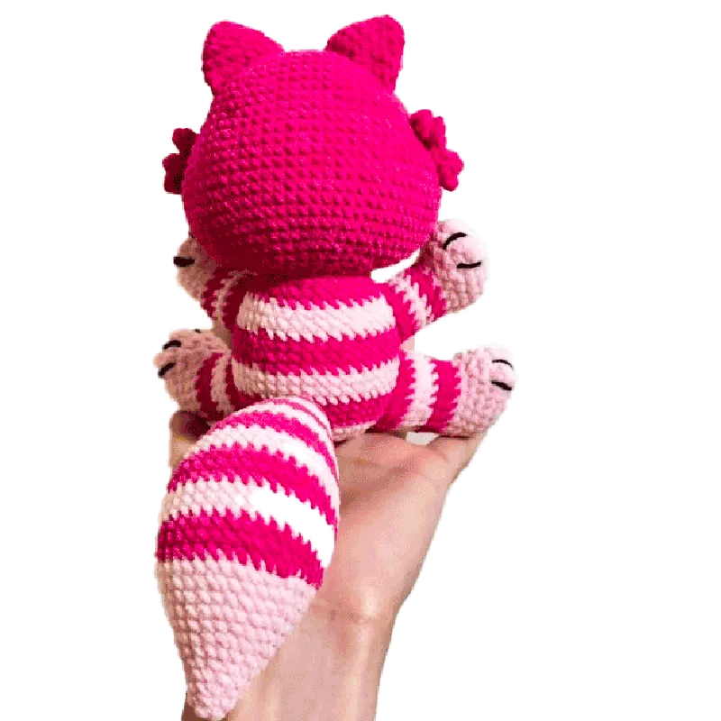 Hand holding a pink and white striped crocheted Cheshire cat using free crochet cheshire cat pattern