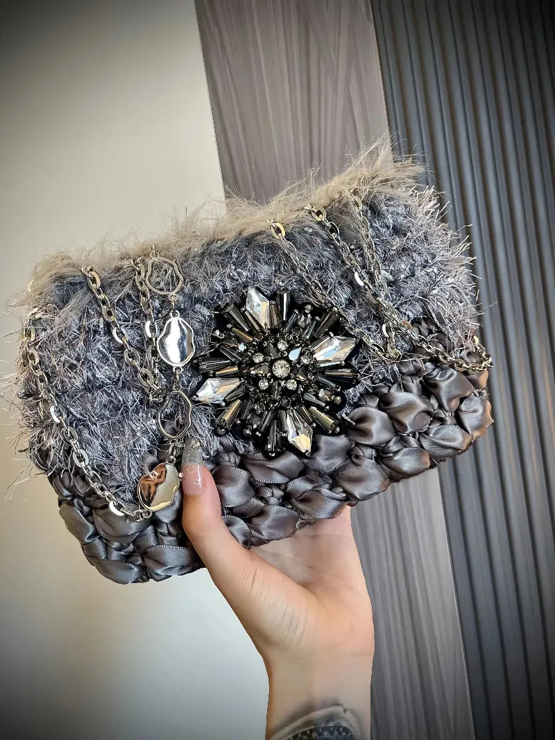 Hand holding a gray crochet purse with fur trim and gemstone embellishment galactic inspired purse pattern