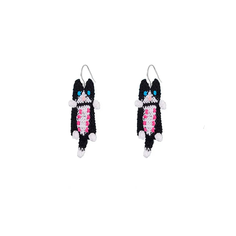Handmade cat earrings featuring blue and black eye design with fuzzy black and pink fringe accents