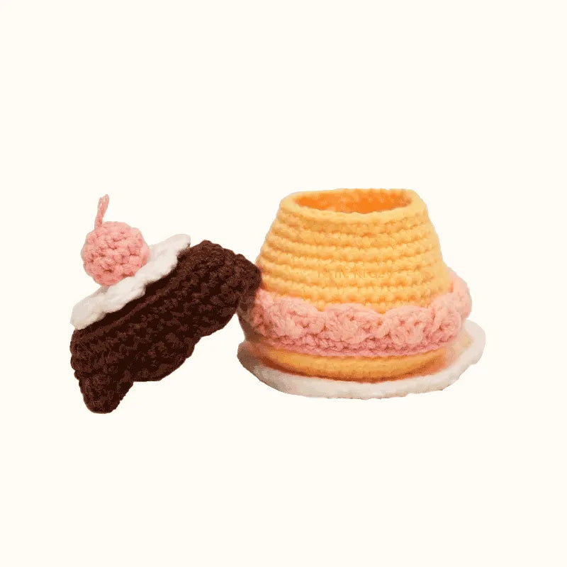 Crochet caramel pudding pattern by The Knit Krazy featuring a yellow pudding with pink and white whipped cream and a chocolate topping with a cherry