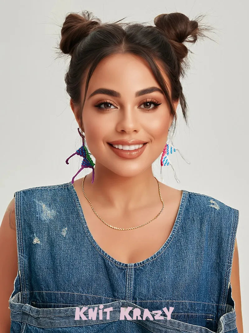 Young woman wearing colorful handmade crochet earrings smiling with denim top and necklace