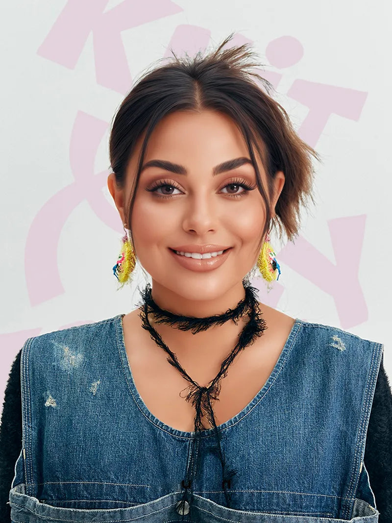 Woman wearing handmade floral snake earrings with colorful detailed design and black choker necklace