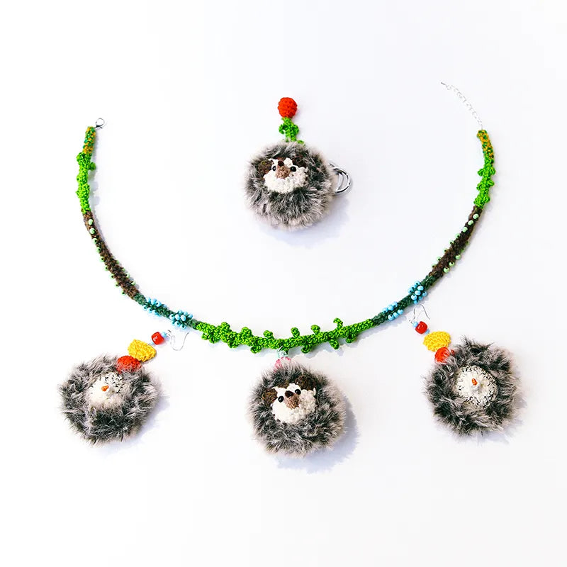 The Knit Krazy handmade hedgehog keychain set with knitted green vine and colorful accents