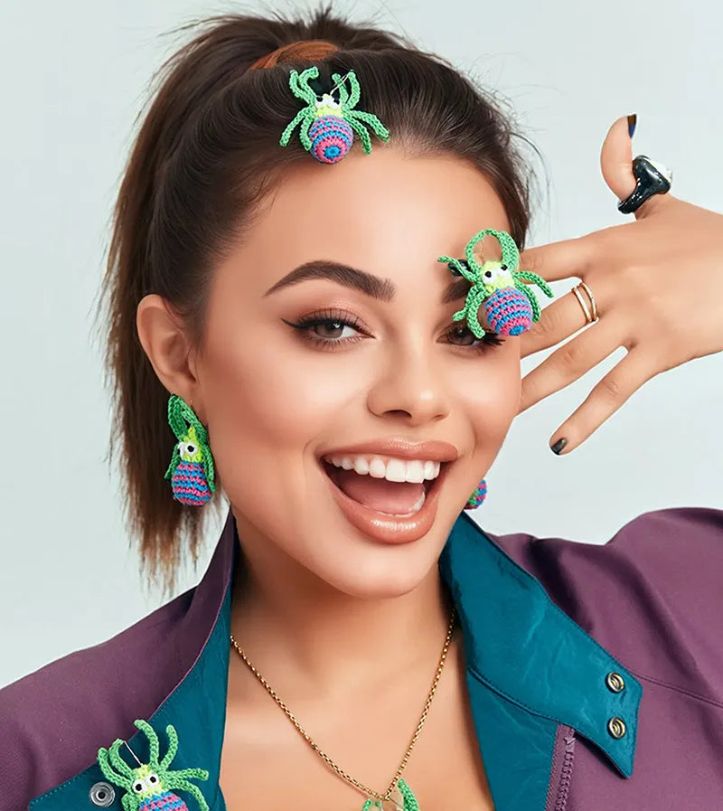 The Knit Krazy handmade spider web earrings worn by smiling woman with matching hair and ring accessories