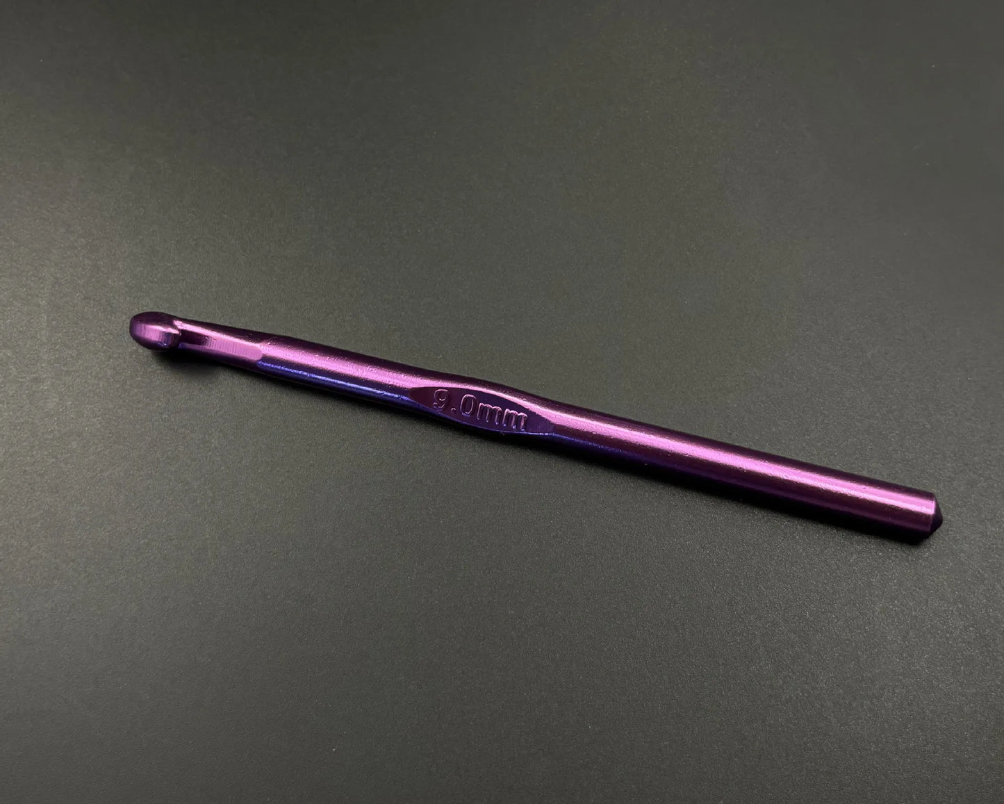 Purple 4.0mm crochet hook from rainbow aluminum crochet hooks set on black background
