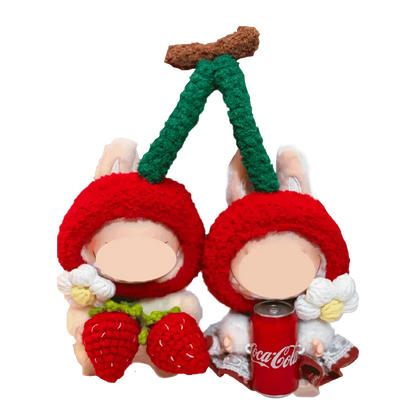 Cherry-themed crochet outfit for plushies featuring red cherry hats with green stems and white flowers