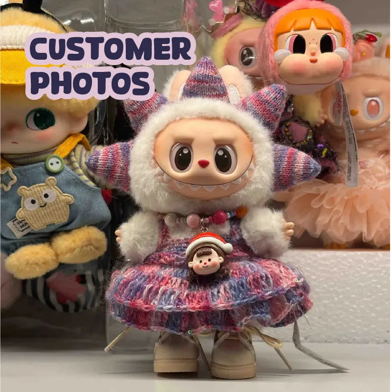 Cute doll wearing a colorful crochet doll dress pattern with a fluffy hood and decorative beads