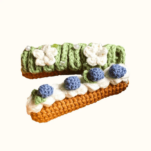 The Knit Krazy crochet eclair pattern beginner kit with green and brown crocheted eclairs decorated with blue and white flowers