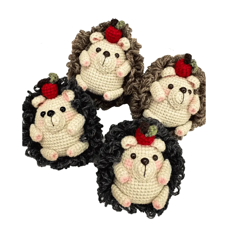 Four handmade crochet hedgehogs with apple decorations using crochet hedgehog pattern