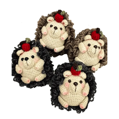 Four handmade crochet hedgehogs with apple decorations using crochet hedgehog pattern
