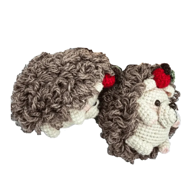 Handmade crochet hedgehog pattern with curly brown yarn and red berry decoration