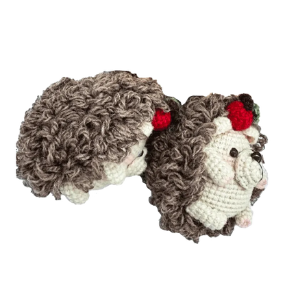 Handmade crochet hedgehog pattern with curly brown yarn and red berry decoration