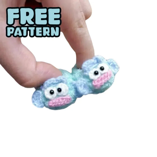 DIY crochet shoes for 17cm plush featuring cute blue monkey face design held by fingers