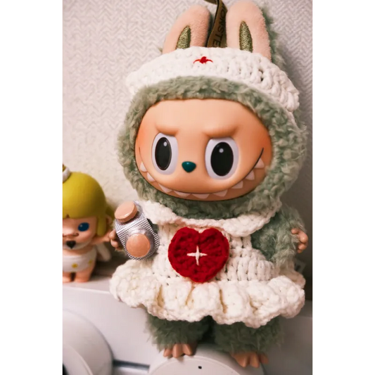 Cute toy doll wearing a handmade crochet nurse outfit holding a small object free crochet nurse outfit pattern 17cm