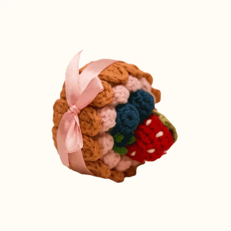 Handmade crochet biscuit cake with berry toppings and pink ribbon using crochet biscuit cake pattern