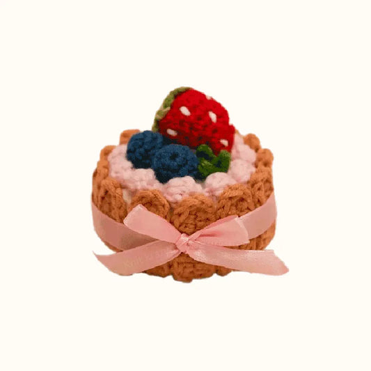 Handmade crochet biscuit cake topped with crocheted strawberries and blueberries with pink ribbon crochet biscuit cake pattern