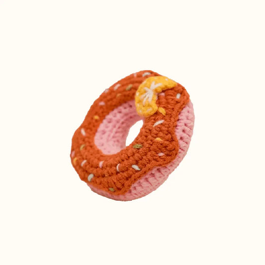 Handmade crochet donut with orange frosting and yellow detail using crochet donut pattern