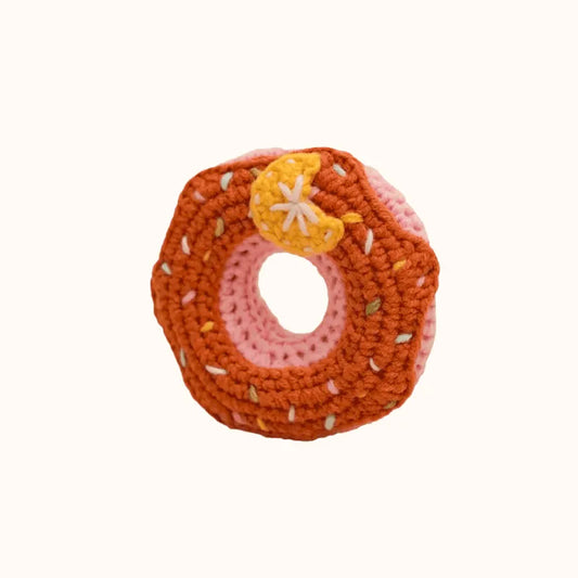 Handmade crochet donut with pink center and brown icing featuring a small yellow flower detail crochet donut pattern