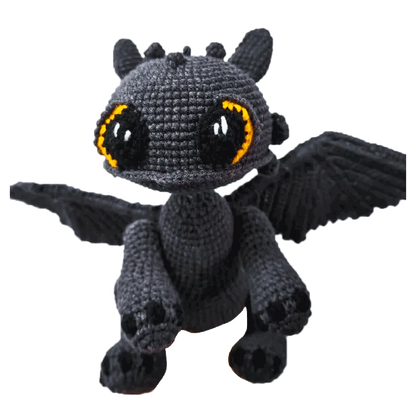 Handmade Toothless crochet gift featuring a black dragon with large orange and black eyes and spread wings