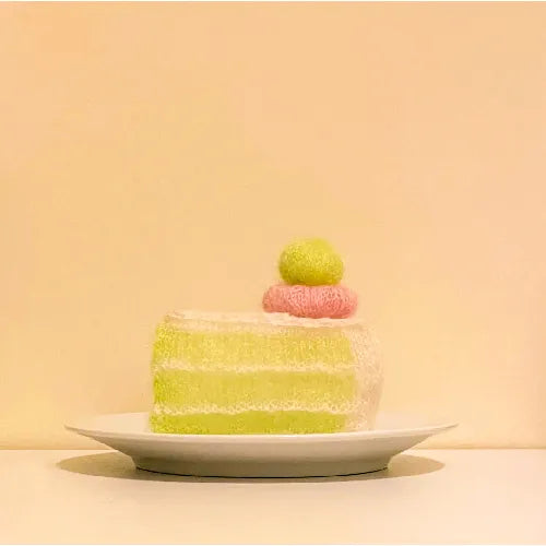 Melon grape dessert crochet pattern showing a crocheted slice of cake with green and pink yarn decorations