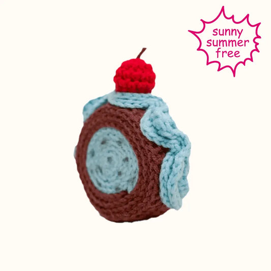 Realistic swiss roll crochet with brown and blue yarn and a red cherry on top by The Knit Krazy