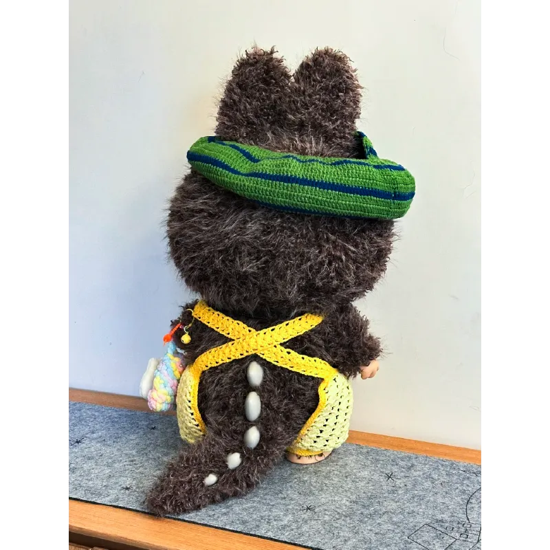 Handmade crochet animal figure wearing Zimomo crochet outfit pattern with yellow shorts and green headband