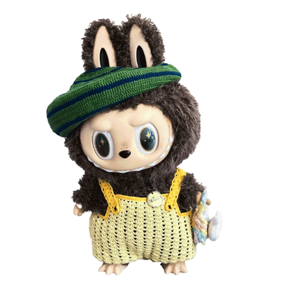 Zimomo crochet outfit pattern featured on a plush toy wearing a yellow crocheted dress and green striped hat